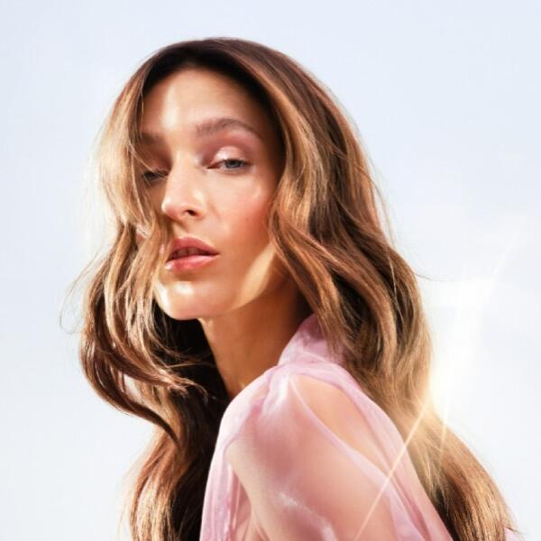 An elegant woman in a pink dress with long, flowing hair.