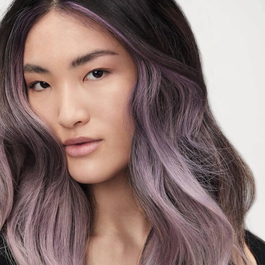 A woman with flowing, purple hair in loose waves.